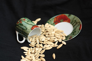 Seeds spilling out of a cup onto a saucer